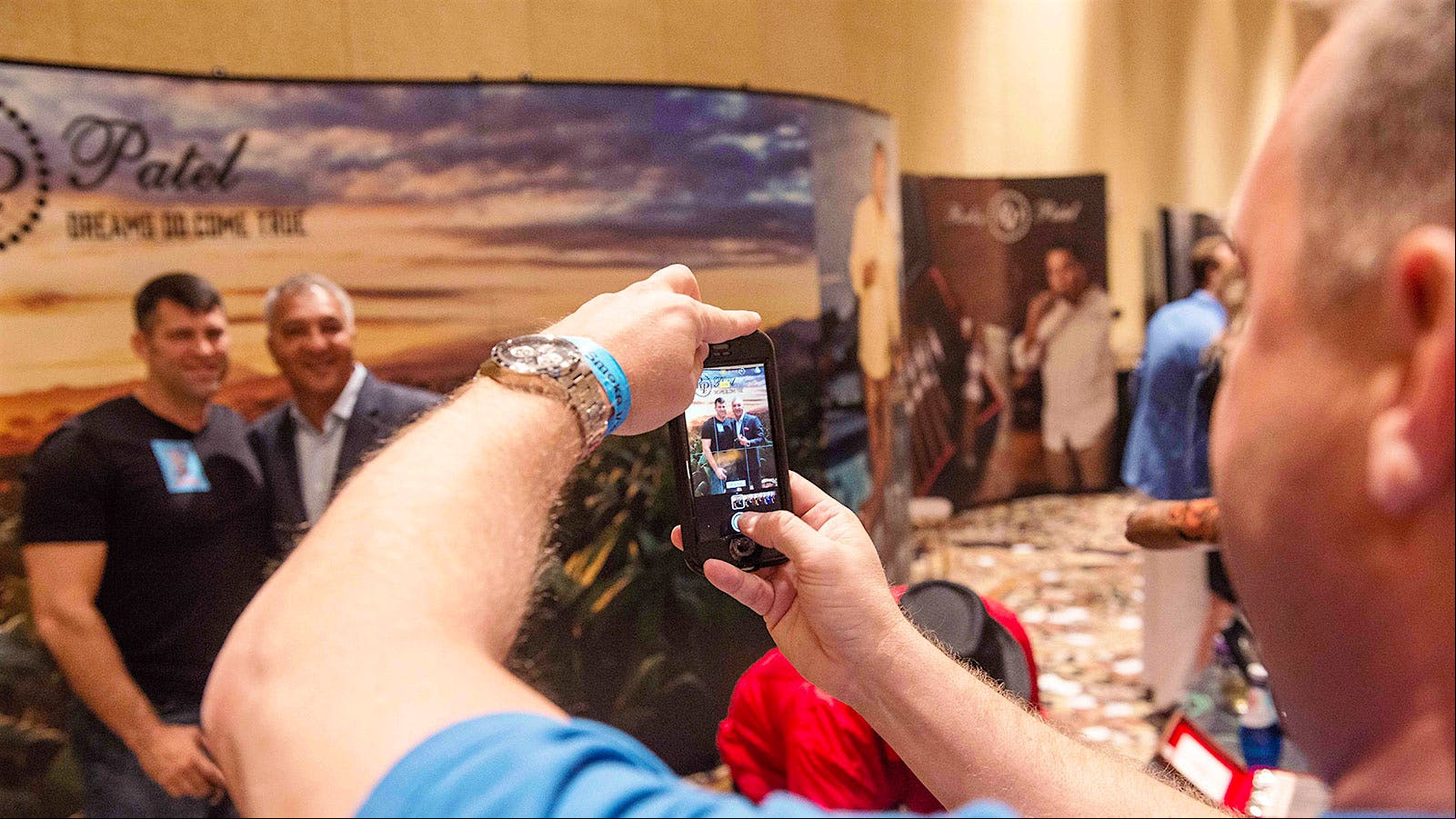 A fan snaps a photo with cigar icon Rocky Patel.